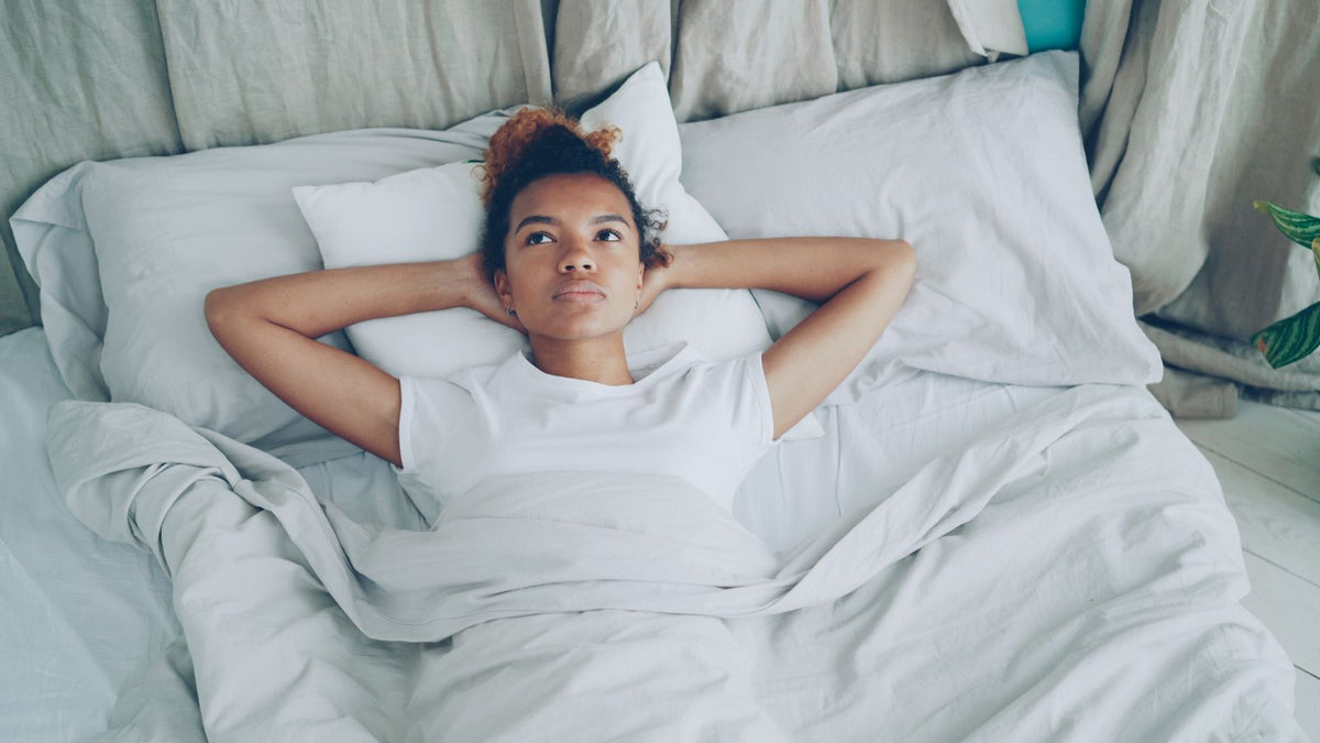 A woman resting thoughtfully in bed