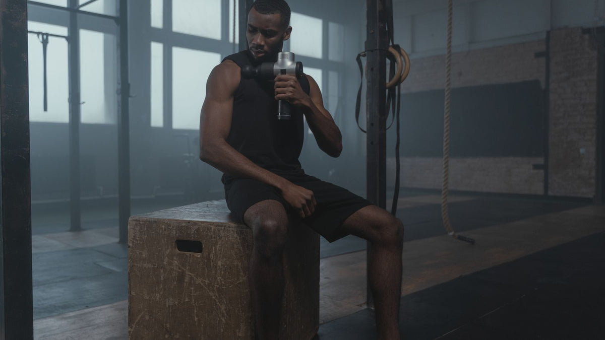 Fit man using a recovery device in a gym