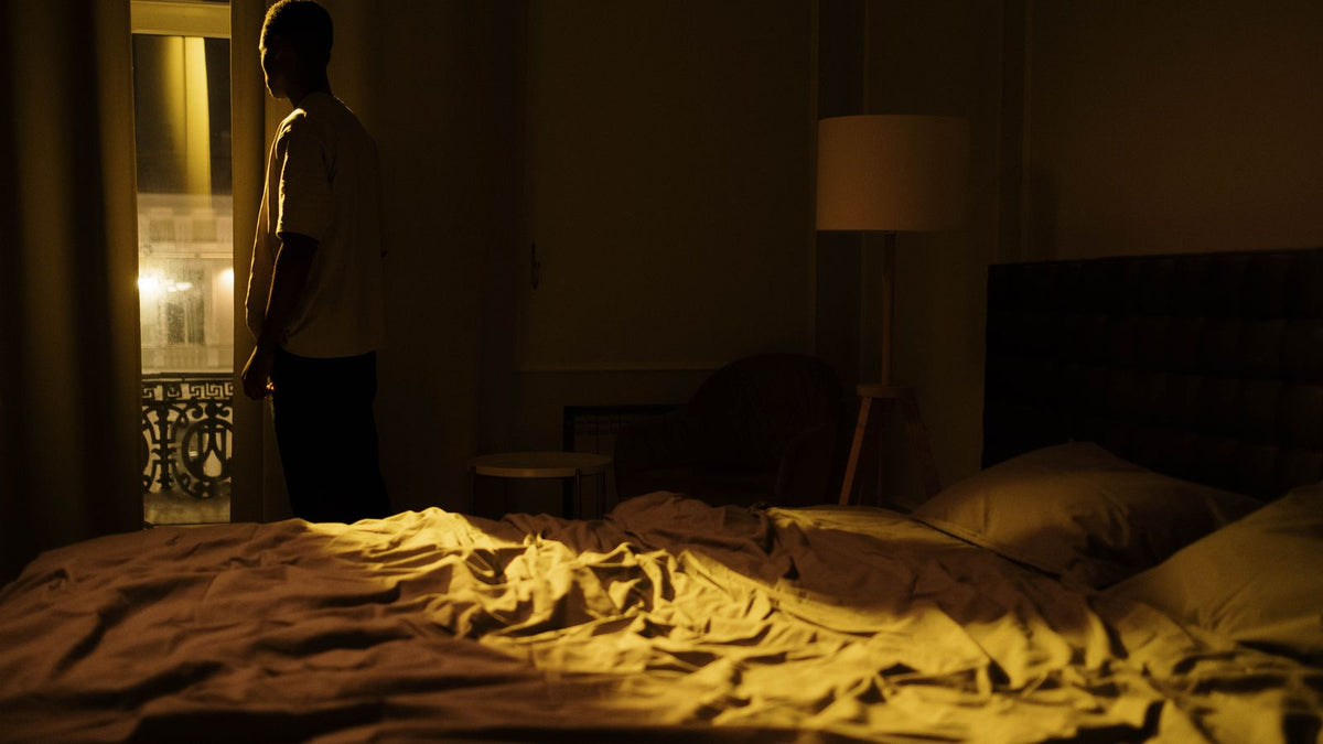 Man gazing thoughtfully out of a window at night