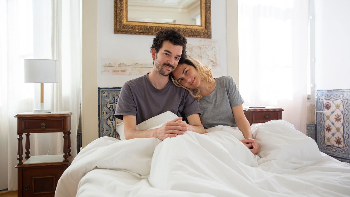 A happy couple relaxing together in bed