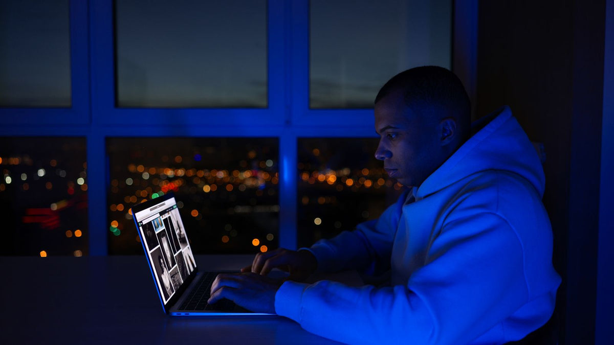 A man using a laptop at night