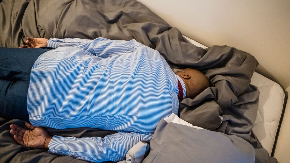 Frustrated man lying face down on a bed