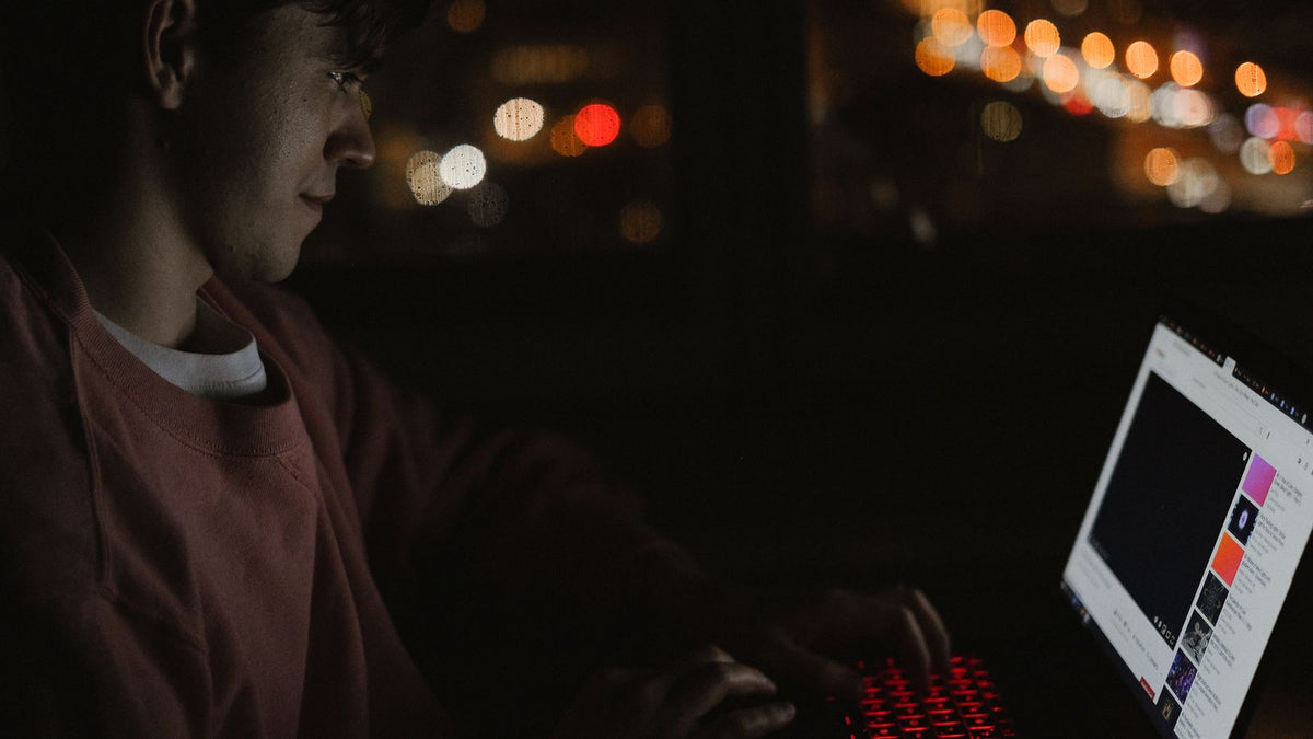 A man alone on a laptop at night