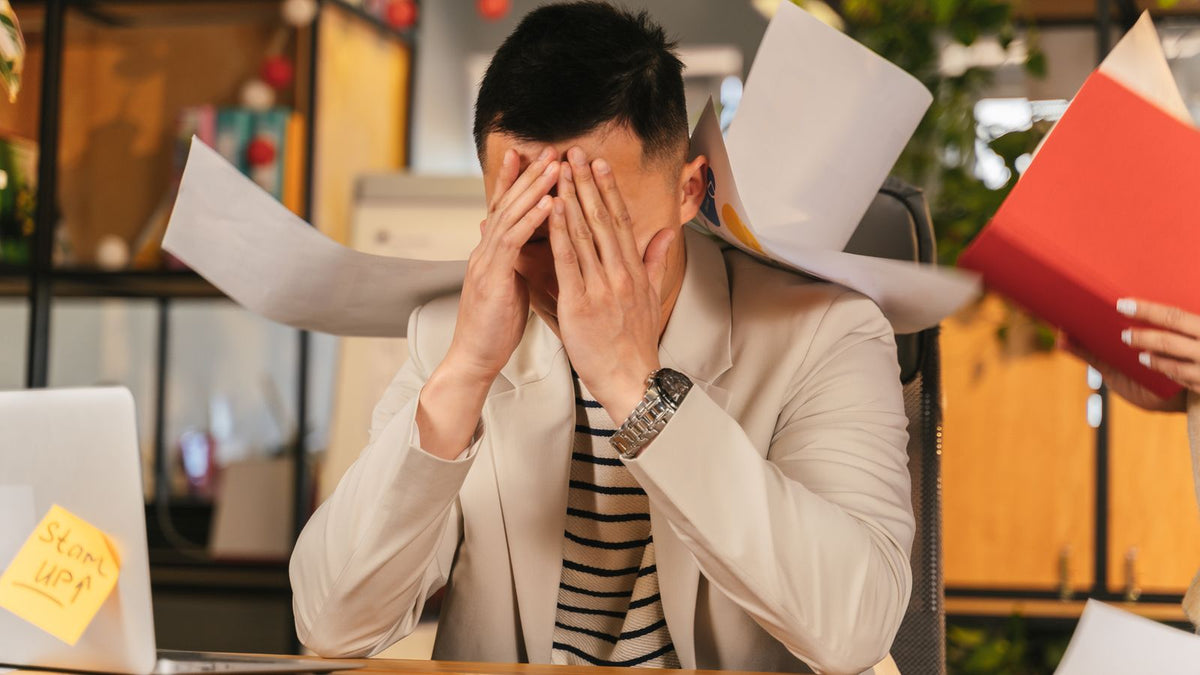 A stressed man overwhelmed at work